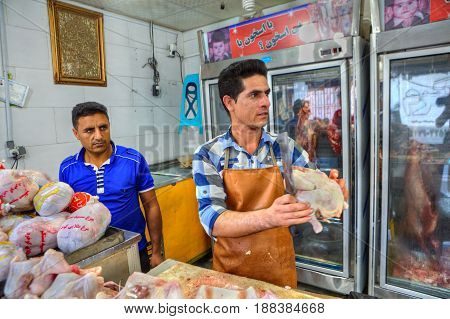 Bandar Abbas Hormozgan Province Iran - 16 april 2017: A meat shop near the grand oriental bazaar the worker cuts off chicken carcasses.