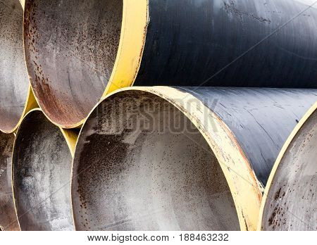 Stack of new metal pipes with yellow-painted edges. Industrial material.