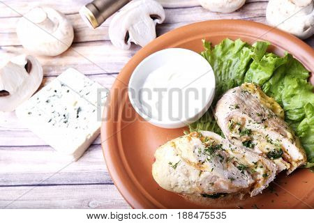 Chicken fillet with bacon and Dorblu cheese and white sauce. Top view