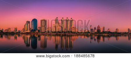 Cityscape image of Benchakitti Park at sunset in Bangkok Thailand.