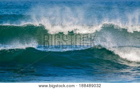 waves breaking into the shore in the late afternoon