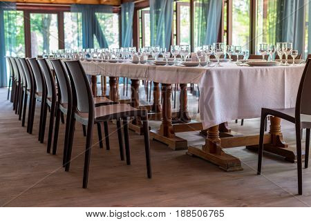 Interior Of The Restaurant, Cafe. Tables With Utensils, Plates, Wiches, Knives, Glasses And Wine Gla
