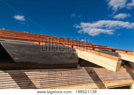 Construction of a wooden roof in an ecological house. External work on the building envelope. The wooden structure of the house near the forest