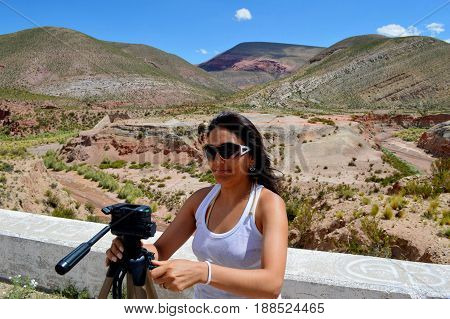 Beautiful assistant photographer preparing the shot in a colorful landscape