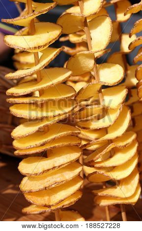 Fried Sliced Potatoes Stuck In The Wooden Skewer Into The Street