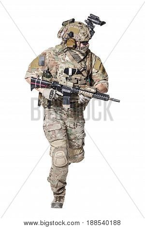 Elite member of US Army rangers in combat uniforms with his shirt sleeves rolled up, in helmet, eyewear and night vision goggles, running in action turning around. Studio shot, white background
