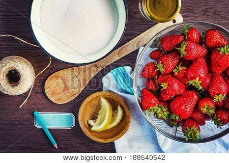 Top view of fresh strawberries sugar and lemon zest. Strawberry jam ingredients prepared to be cooked.