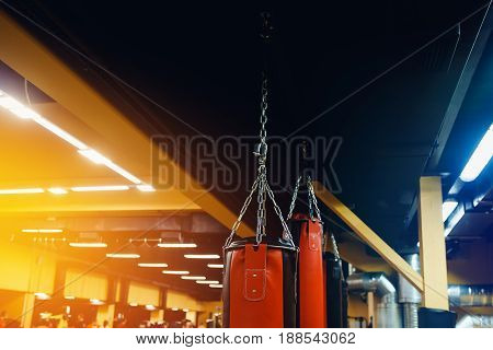 Punching bag in the gym. Against the backdrop of athletes. Gym is a cellar. high contrast and monochrome color tone.