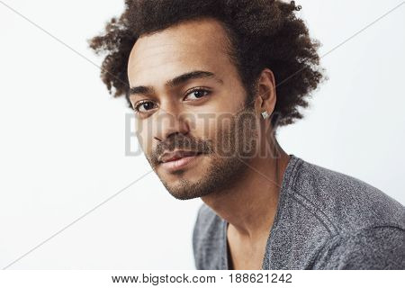 Portrait of young handsome african man looking at camera over white background.