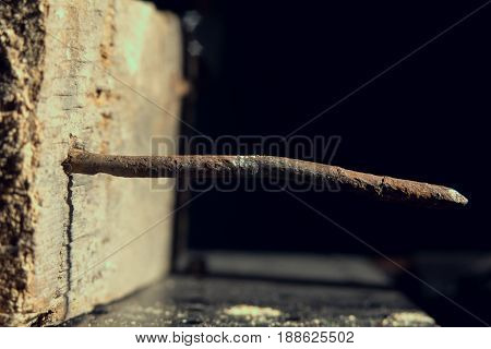 Rusty Nail Sticks Out Of An Old Wooden Board