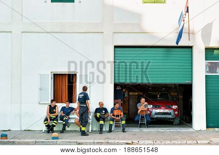 Omis Croatia - August 18 2016: Firemen having a break and sitting at fire station in Omis Croatia