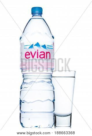 London, Uk - May 29, 2017: Bottle Of Evian Natural Mineral Water With Glass On A White. Made In Fran