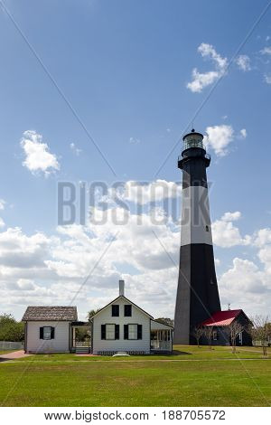 Tybee Island Lighthouse a historic lighthouse with colonial era ties near Savannah Georgia. Classic lighthouse image with fluffy clouds and sunny skies.