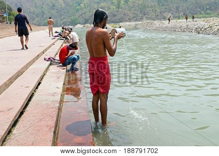 RISHIKESH, INDIA - APRIL 17, 2017: A Hindu sadhu taking a bath at the holy river Ganges in Rishikesh on the 17th april 2017 in India