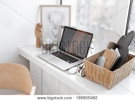 Creative workplace on windowsill in modern room