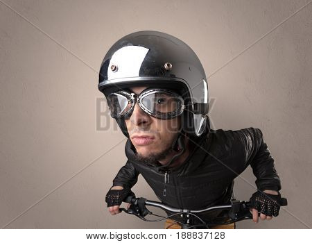Nerd young foolish biker on a bike with oldschool outfit