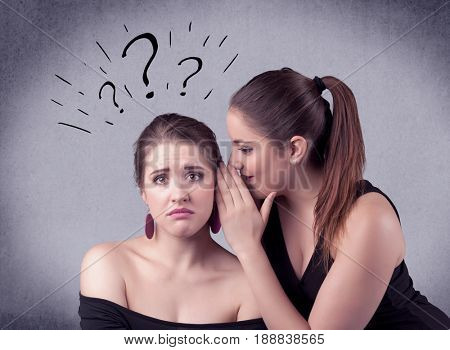 A teenager girl looking confused with drawn question marks above the head, while a girlfriend whispers something in her ear concept.