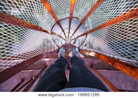 POV looking down a rusted old ladder on a water tower