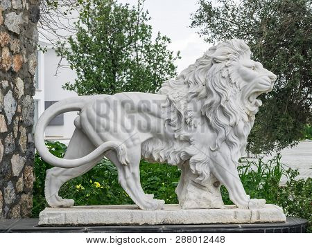 City Sculpture Of A White Lion With Open Mouth At The Entrance. Local Landmark