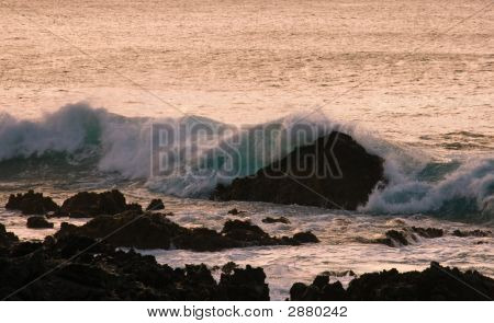 Burácení vln na skále v západu slunce