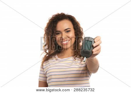 Young African-american Woman Holding Glucometer On White Background. Diabetes Control