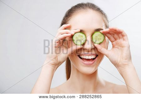 Photo Of Attractive Young Woman Covering Her Eyes With Cucumber