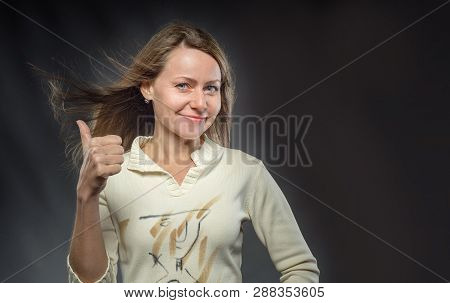 Portrait Of Young Beautiful Woman With Hair Flying In Wind Against Black Background. Attractive Brun