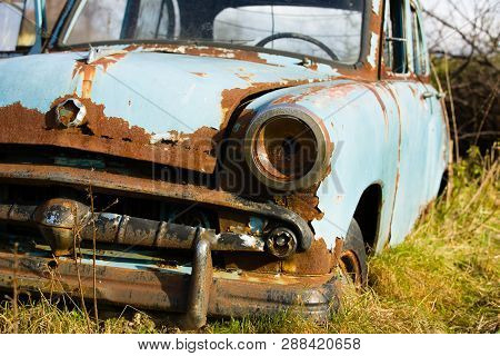 Old, Abandoned Rusty Car Wreck Front And Lamp.