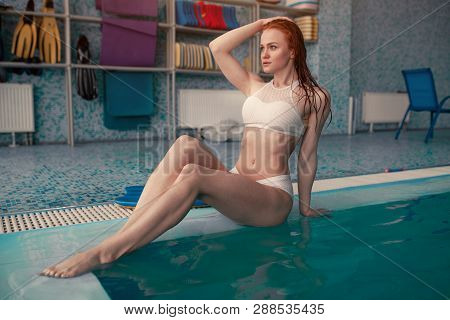 Beautiful Young Woman In The Indoor Swimming Pool. Athletic Sexy Girl. Healthy Lifestyle. Wellnes We