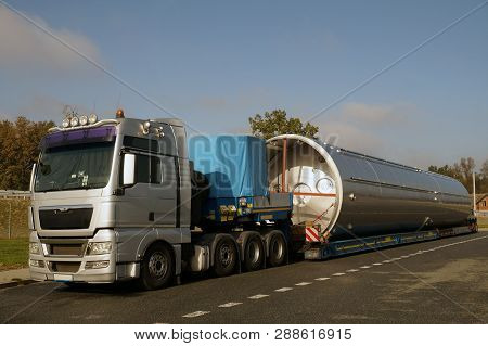 View Of A Silver Truck, Low-loader Semi-trailer And Oversized Load.