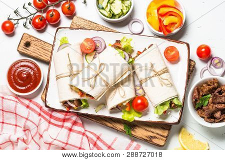Burritos Tortilla Wraps With Beef And Vegetables On White Wooden Background.  Latin American Food. T