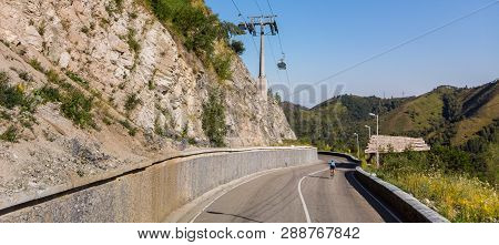 A Man Riding A Road Bike On A Mountain Road
