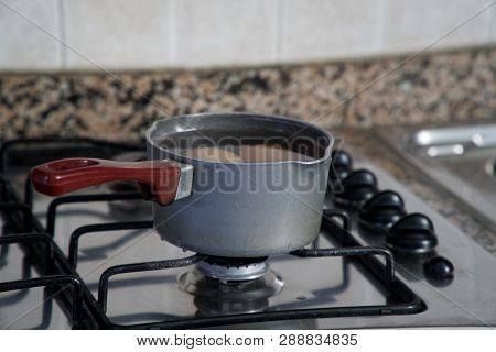 Boiled Eggs In Dipper Of Water On The Kitchen Stove.