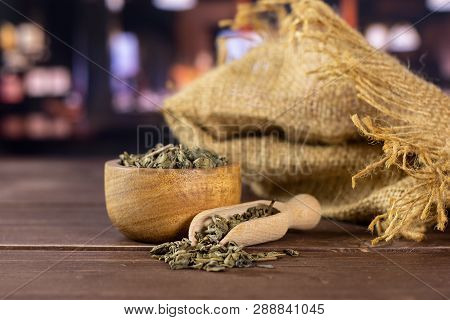 Lot Of Pieces Of Dry Green Tea In A Scoop With Wooden Bowl In A Restaurant
