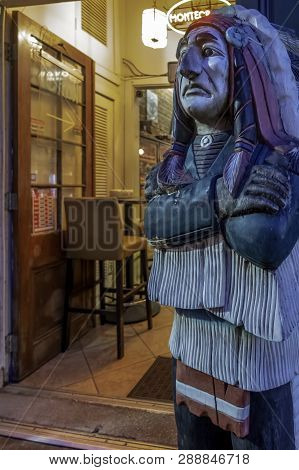New Orleans, Usa - Dec 4, 2017: A Night Cafe On Conti Street, With A Life-size Wooden Statue Of An I