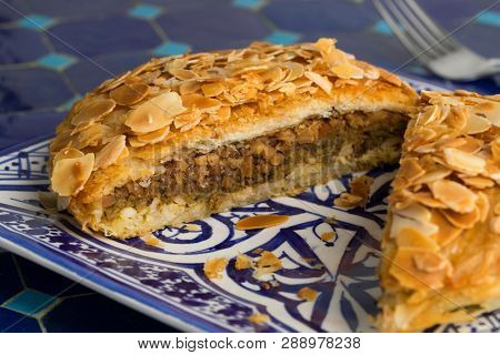 Dish with traditional Moroccan small bastella stuffed with chicken and topped with roasted almond 