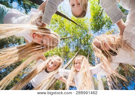 A Group Of Girls Hugging Themselves Formed A Circle, Bent Down, Looking Down. Walk In The Summer For