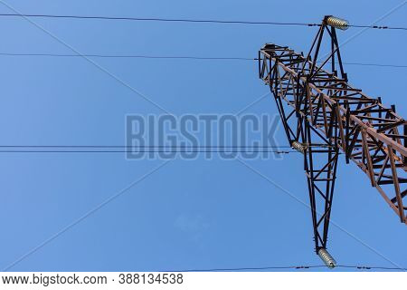 Steel Structure Of A Power Line Steel Tower. Tower Is Against Clear Blue Cloudless Sky. Communicatio