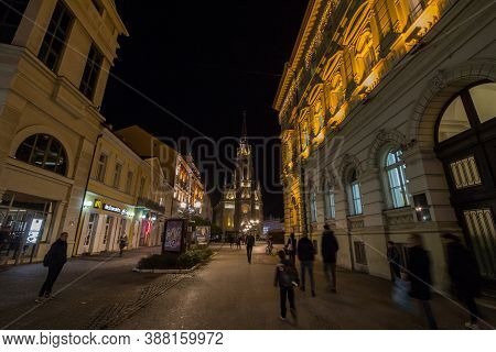 Novi Sad, Serbia - November 18, 2019: People Walking At Night With A Speed Blur Movement Near The Na