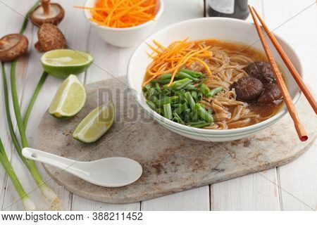 Shiitake mushrooms and soba noodle soup with carrot, green onion, and lime