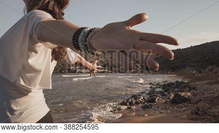 Young Woman With Outstretched Hands Doing Yoga In Early Morning On The Beach. High Quality Photo