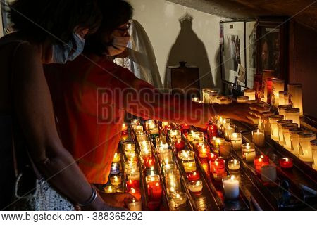Saintes Maries De La Mer - 09/04/2020: People Lighting Votive Candles