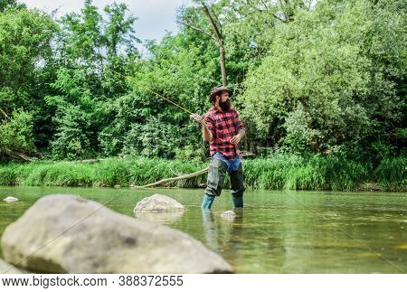 Experience The Legend. Experienced Fisher In Water. Man Catching Fish. Mature Man Fly Fishing. Fishe