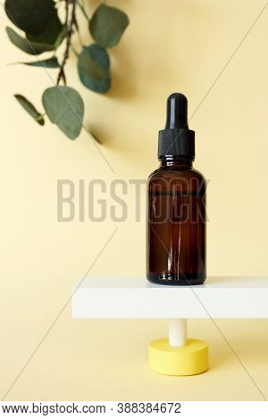 Collagen Peptide Serum Facial Moisturizer Bottle Standing On Abstract Pedestal On Pastel Yellow Back