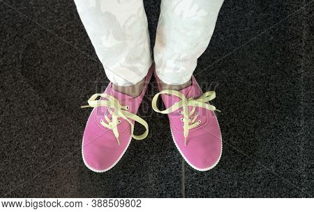 Pink Sneakers With Yellow Shoes Lace On Girl, Young Woman Legs, Outdoors On Black Marvel Flloor