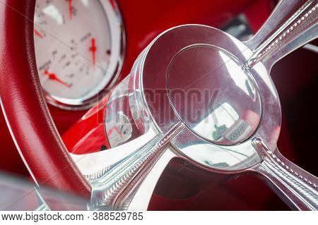 Steering Wheel With Crome Beams, Fuel, Oil, Water, Volts Dials On Front Panel Of Red Old Timer Car