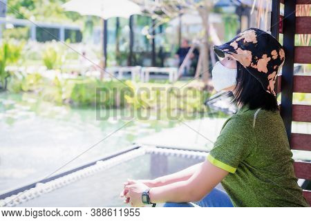 Asian Woman Wears A Protective Mask Is Relaxing And Thinks Of A Good Time With Green Background Duri