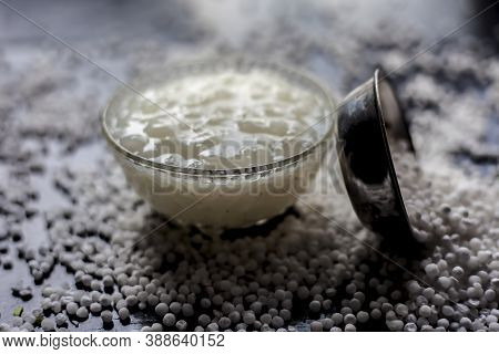 Close Up Shot Of Sabudana Ki Kheer In A Glass Bowl Along With Some Raw Tapioca Pearls And Sugar Spre
