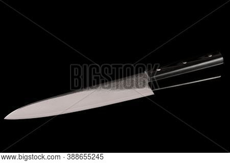 Japanese chef knife with damascus pattern isolated on black background