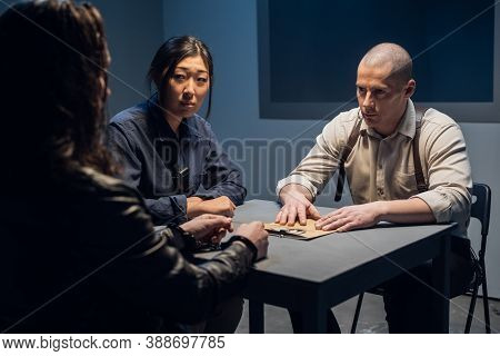 Two Police Officers A Man And A Woman Are Questioning The Alleged Offender At The Police Station.